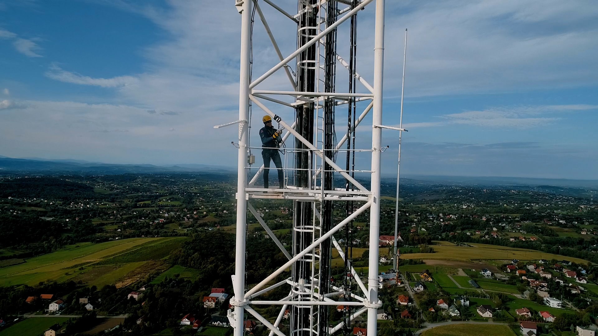 Na zdjęciu znajduje się pracownik na wysokości